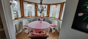 a dining room with a table and chairs and windows at Chaletwohnung Alpenglück in Burgberg +9 photos