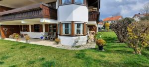 a house with a green yard in front of it at Chaletwohnung Alpenglück in Burgberg