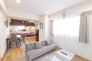 ein Wohnzimmer mit Sofa und Tisch in der Unterkunft Ocean Nipponbashi Higashi in Osaka