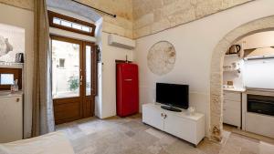 a living room with a red refrigerator and a television at White Rose by Rentbeat in Ostuni