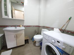 a bathroom with a washing machine and a toilet at Apartment in The Heart of the Capital in Chişinău