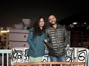 a man and a woman standing on a roof at GreenDay Escapes Rishikesh in Rishīkesh