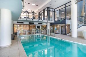 a swimming pool in a building with glass walls at Skyline Serenity - Knightsbridge in Cape Town