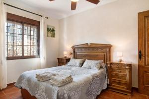 ロンダにあるCasa Ayala Rondaのベッドとタオル2枚のある寝室