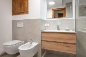 Un baño con un inodoro blanco y un lavabo. en Cozy 3 bedroom with access to garden, en Cortina dʼAmpezzo 13 fotos más