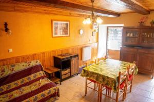 a dining room with a table and a stove and a couch at Le castel in Laval-du-Tarn +5 photos