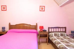 two beds in a bedroom with pink sheets at Le castel in Laval-du-Tarn