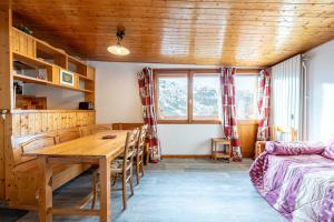 a room with a wooden table and a bed and a desk at Appartement 22 - 5 personnes in Les Allues
