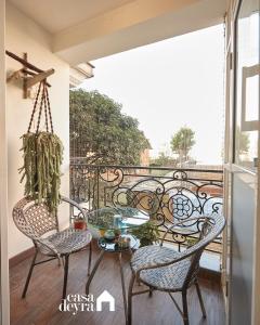 a balcony with two chairs and a glass table at Elegant Edge 3BHK Apartment in Pātan