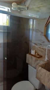 un bagno con wc e doccia in vetro di Triplex 3 Suítes 10 PESSOAS Cond Aldeia dos Pescadores Praia do Forte a Praia do Forte