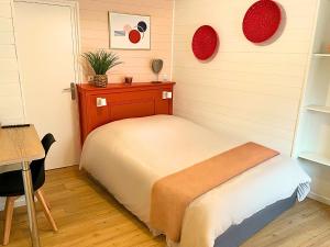 a small bedroom with a bed and a table at Studio moderne et tout équipé au cœur de Bourbourg - gare à proximité in Bourbourg +6 photos