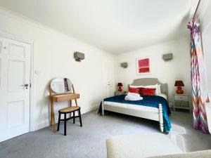 a bedroom with a bed and a chair in it at Split Level 2 Bed Apartment- Mayfair in London