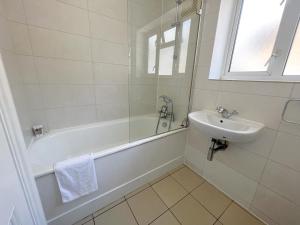 a white bathroom with a sink and a tub and a sink at Split Level 2 Bed Apartment- Mayfair in London