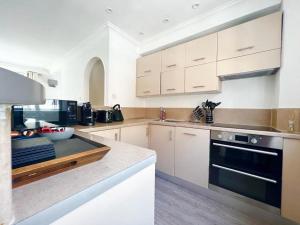 a kitchen with white cabinets and a stove top oven at Split Level 2 Bed Apartment- Mayfair in London +12 photos