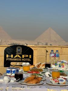 stół z talerzami żywności przed piramidami w obiekcie Hapi Pyramids Hotel w Kairze
