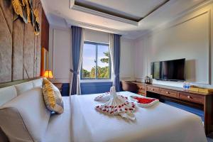 a hotel room with a white bed and a television at S79 Hotel Happy 88 Tran Hung Dao Street in Phu Quoc