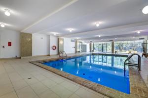 a large swimming pool with blue water in a building at Appartements Dorchester in Montreal
