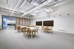 a classroom with tables and chairs and a chalkboard at Appartements Dorchester in Montreal