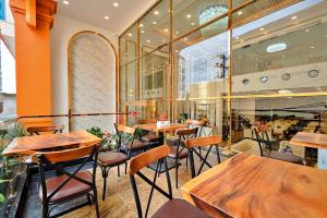 a restaurant with wooden tables and chairs at S79 Hotel Happy 88 Tran Hung Dao Street in Phu Quoc