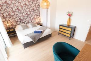 a bedroom with a bed and a chair at Elégant Appartement 2 chambres bord de mer par Groom in Ploemeur