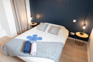 a bedroom with a bed with a blue flower on it at Elégant Appartement 2 chambres bord de mer par Groom in Ploemeur +11 photos