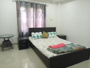 a bedroom with a bed with pillows and a table at Luxury Bonafide Villa in Lohārghāt