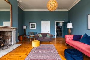 a living room with a couch and a fireplace at Grand Georgian Townhouse with Garden in Bath +48 photos