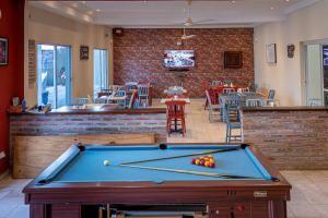 a pool table in a room with a restaurant at Ocean Villa Heights in Brufut