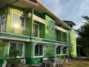 北碧ท่าช้างรีสอร์ท กาญจนบุรี的带阳台的绿色白色建筑