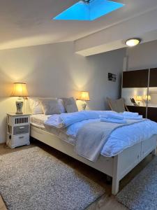 a bedroom with a large white bed with blue sheets at Family Villa Lake View in Moara Vlăsiei