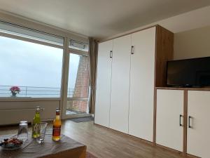 a living room with white cabinets and a large window at Klaar Kiming 5c, Sandwall in Wyk auf Föhr
