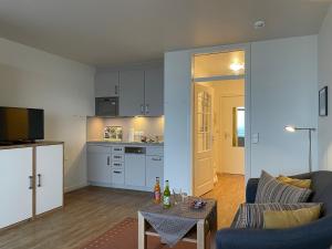 a living room with a couch and a table at Klaar Kiming 5c, Sandwall in Wyk auf Föhr +9 photos