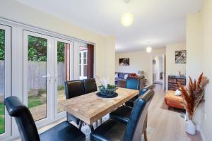 a dining room with a wooden table and chairs at Modern Comfort 4 Bedroom, 3 Bath House in Maidenhead in Maidenhead
