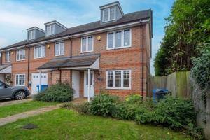 a brick house with a car parked in front of it at Modern Comfort 4 Bedroom, 3 Bath House in Maidenhead in Maidenhead