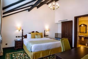 a hotel room with a bed and a desk and a table at Midland Hotel Nakuru in Nakuru +28 photos