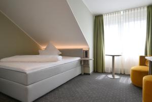a hotel room with a bed and a window at Hotel Restaurant Zur Post Lohfelden in Kassel