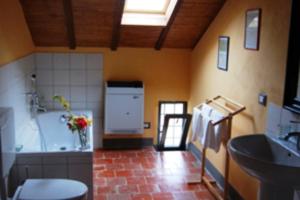a bathroom with a tub and a sink in a room at Tenuta Rivalazzo in Noceto