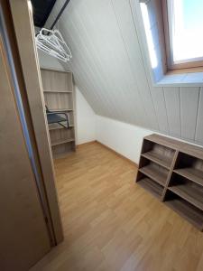 a attic room with a window and wooden floors at Appartement de l angle Im Winkel in Oberbetschdorf