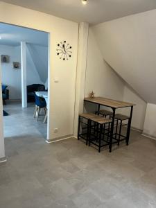 a dining room with a table and a clock on the wall at Appartement de l angle Im Winkel in Oberbetschdorf +3 photos