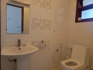 a bathroom with a sink and a toilet at Elephant Legacy Staycations in Mombasa +8 photos