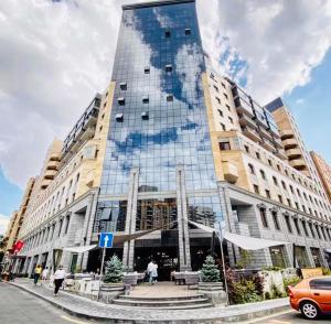 a tall building with glass windows on a city street at Apartments by GR Yerevan in the city centre in Yerevan