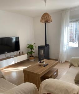 a living room with a couch and a table and a tv at Bajo en Pliego - Tranquillity and Natural Beauty in Pliego
