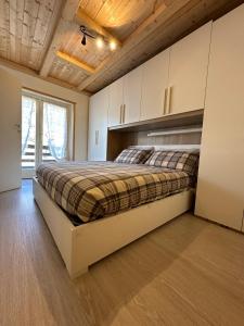una camera da letto con un letto grande in una stanza di Appartamento in centro a Ponte di legno a Ponte di Legno