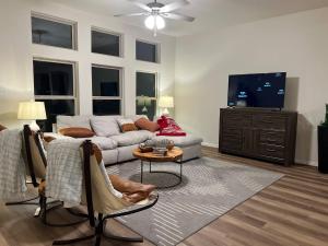 a living room with a couch and a tv at Balmoral LakeSide 5br 4ba House in Humble