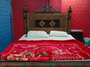 Un dormitorio con una cama con una colcha roja. en City Palace Hotel Lahore, en Lahore 8 fotos más