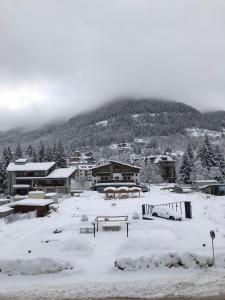una città coperta di neve con una montagna sullo sfondo di Appartamento in centro a Ponte di legno a Ponte di Legno Altre 7 foto