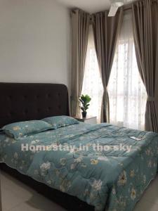 a bed with a blue comforter with the words home slept in the sky at Puncak Alam Homestay in Kampong Bukit Hijau