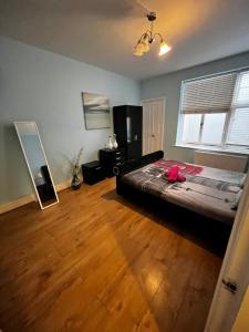 a bedroom with a large bed and a wooden floor at Keysan House in London +37 photos