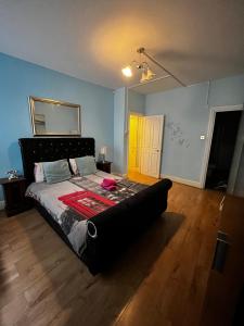 a bedroom with a bed with a black headboard at Keysan House in London