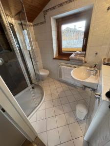 ein Badezimmer mit Dusche, Waschbecken und Toilette in der Unterkunft Erika´s Häuschen in Kitzbühel + 18 Fotos